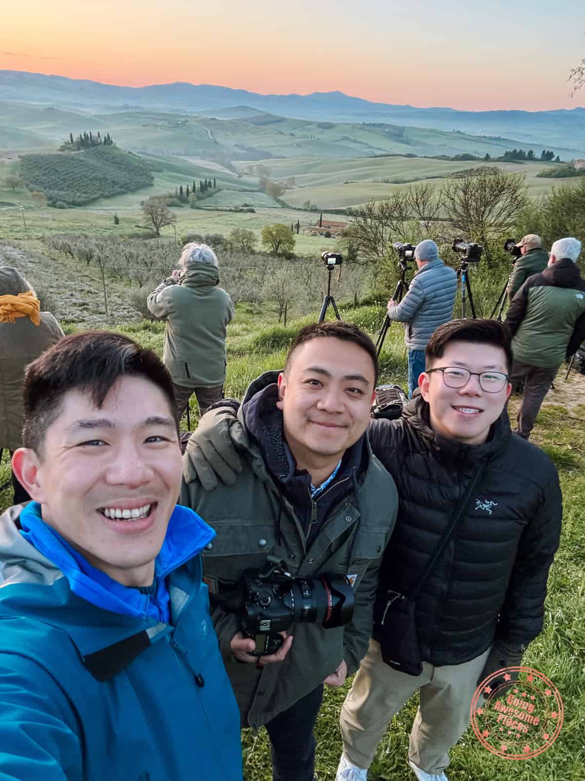 3 asian guys with line of photographers behind for sunrise at podere belvedere