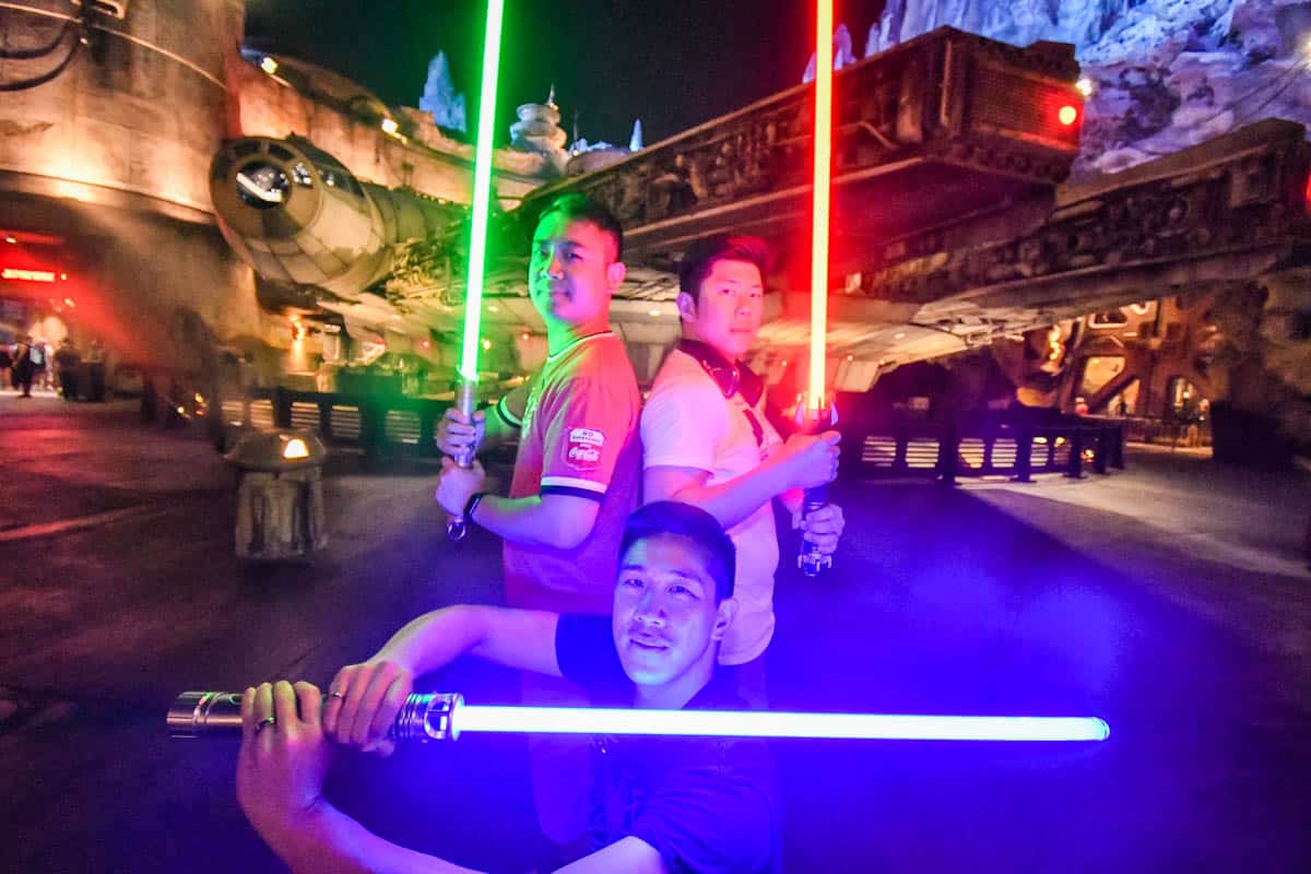 3 star wars fans with lightsabers in galaxy's edge which is for free using genie+ and the photopass feature