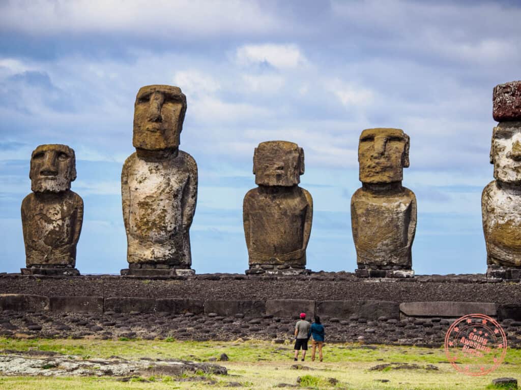 ahu tongariki scale with two tourists looking at the moai