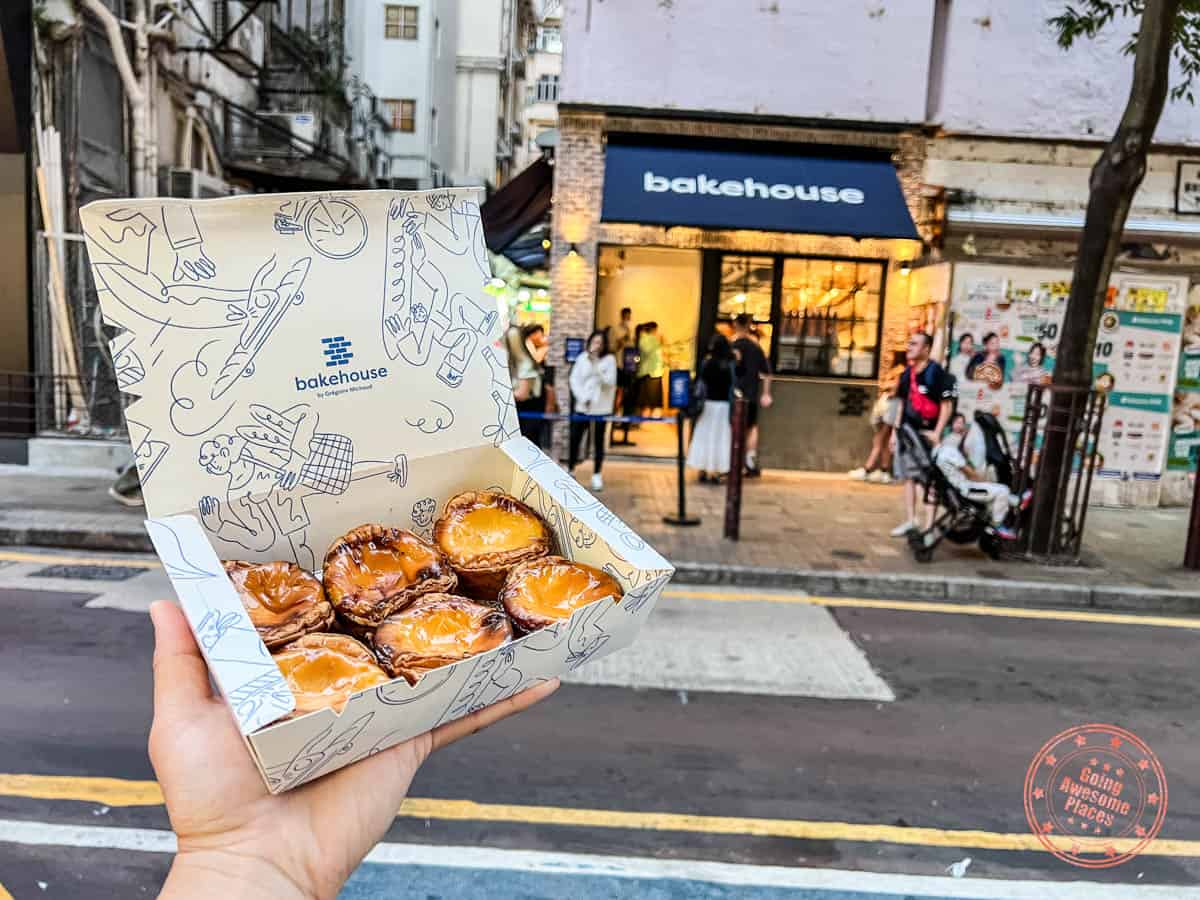 holding a tray of 6 egg tarts from bakehouse in tst hong kong 