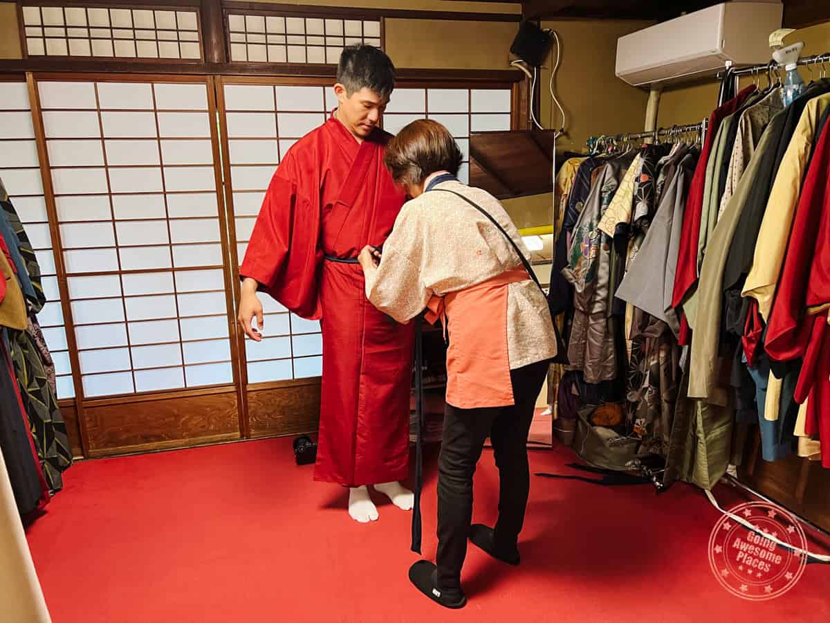 man getting dressed in a kimono in kyoto