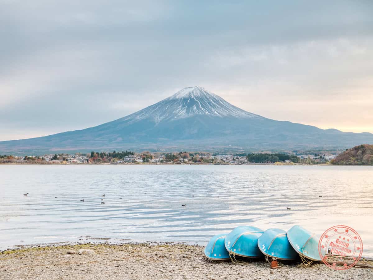 lake kawaguchi with mt fuji in the background and four boats stacked in front