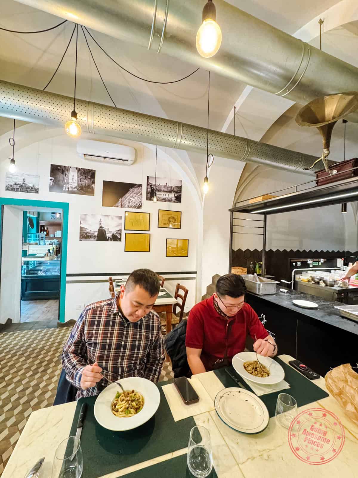 two guys eating lunch at osteria da trombicche siena