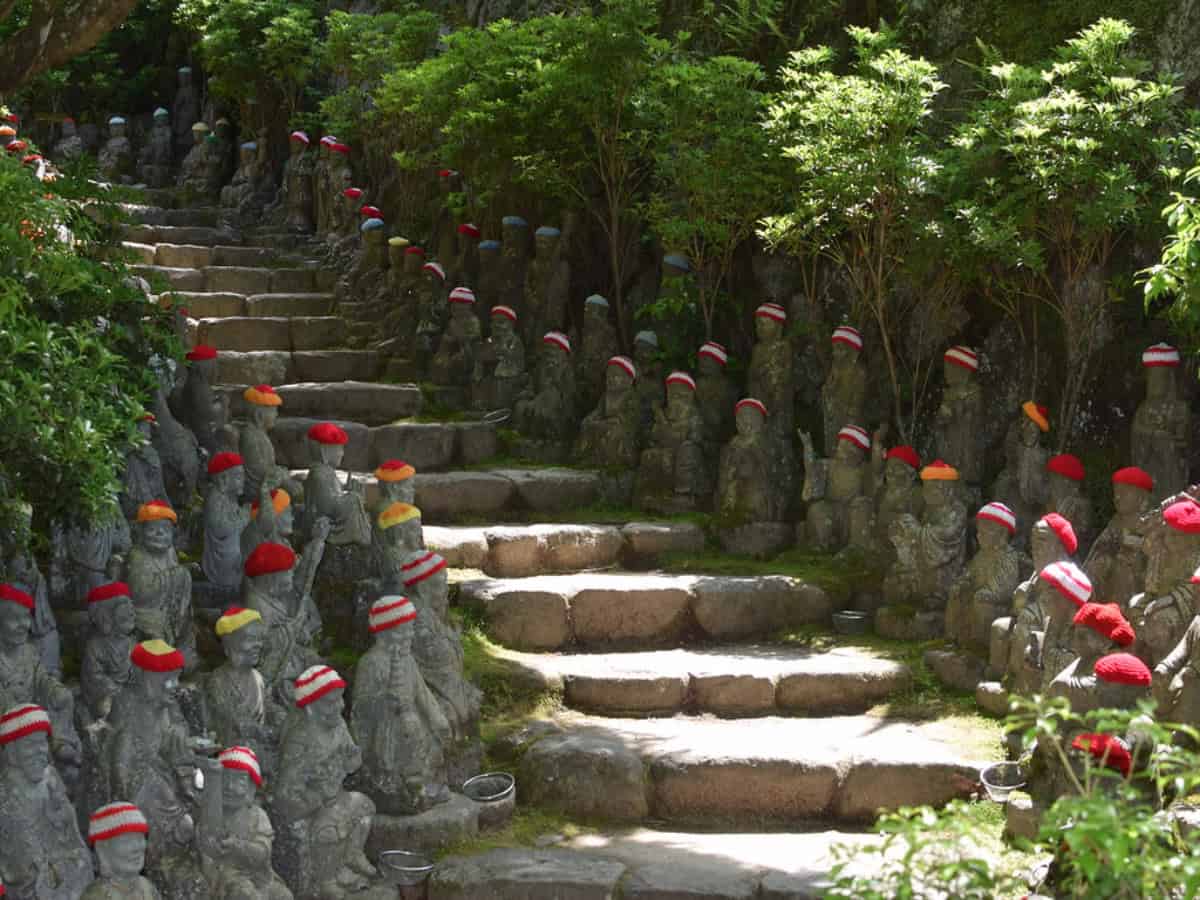 miniature rakan statues in knitted hats lining stairs to daisho-in temple