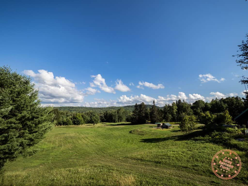 green hills with trees and laurentian mountains in the background at nature's harmony eco-lodge