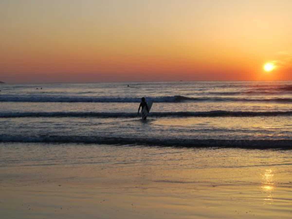 surfer coming out of water at sunset at okuragahama beach