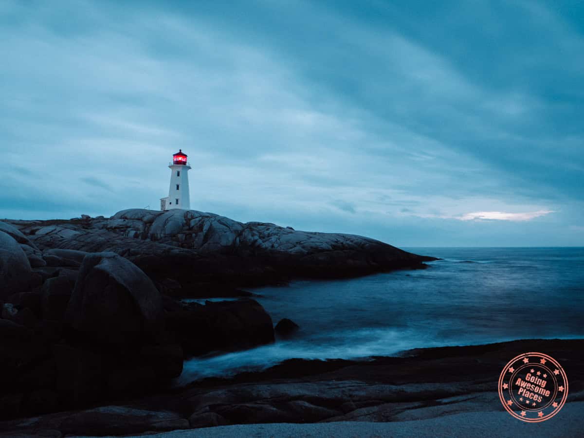 long exposure photo of peggy's cove lighthouse at dusk with crashing waves