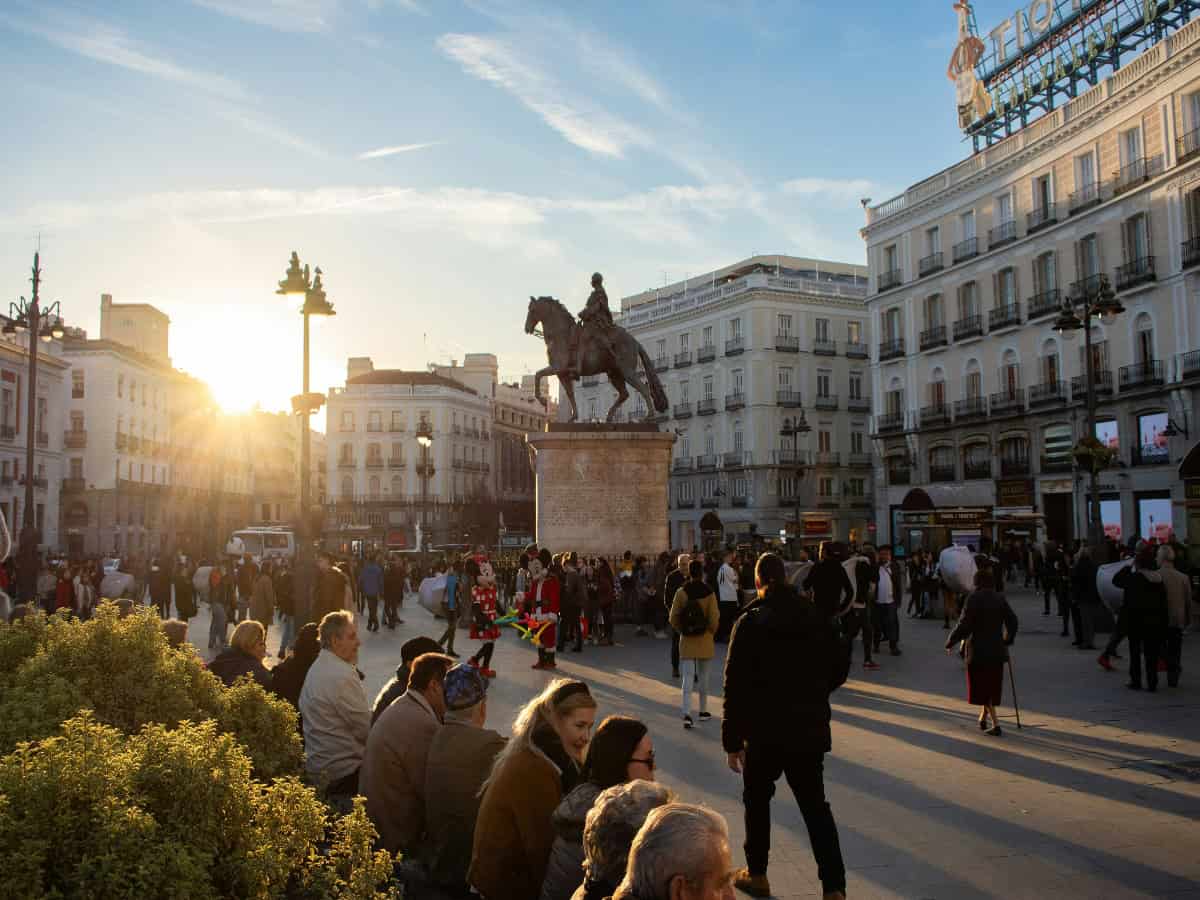 sun shining on busy square in puerta del sol