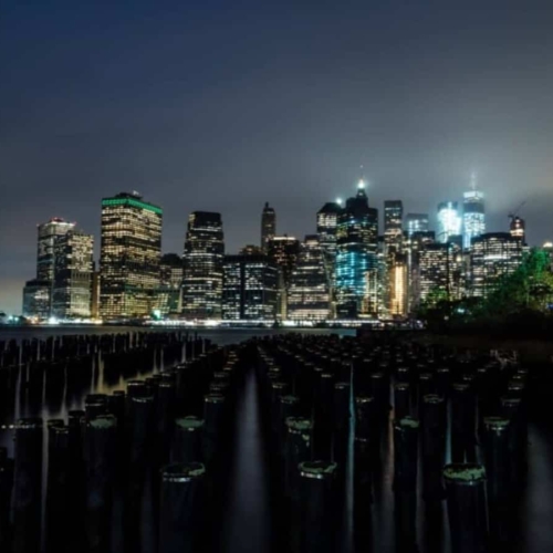 view of nyc lit up at night across the bay