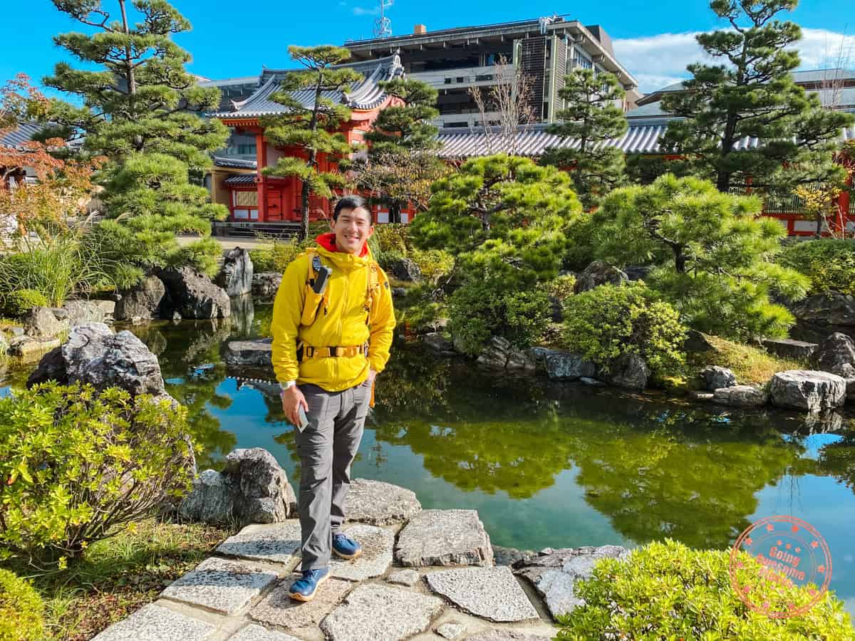 man standing in front of pond and garden in japan showcasing what to wear